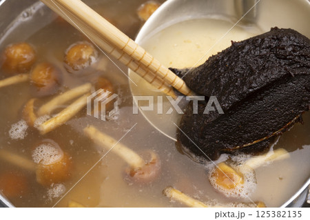 赤味噌を使ったなめこと豆腐の味噌汁を作る工程 125382135
