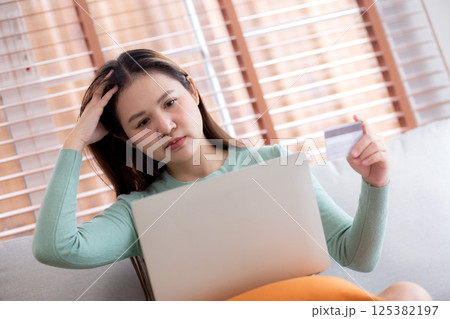 Young asian woman holding credit card or debit card with stress about loan and expense. Young asian woman holding credit card or debit card with stress about loan and expense. 125382197