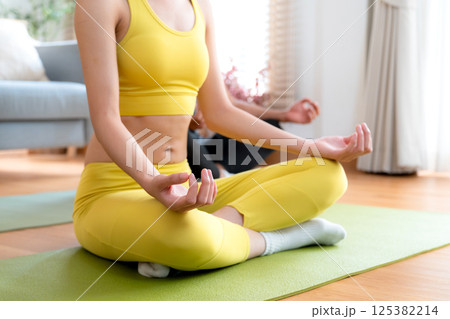 Closeup hands couple practicing yoga and meditation together in the living room at home. Closeup hands couple practicing yoga and meditation together in the living room at home. 125382214