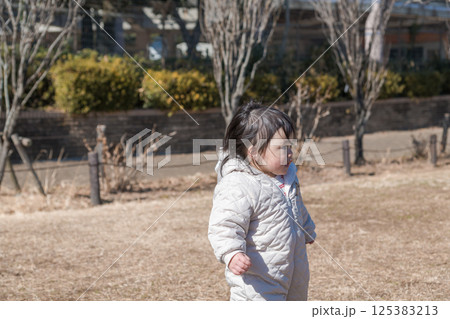 【相模原市立麻溝公園の芝生広場で遊ぶ1歳児】 125383213