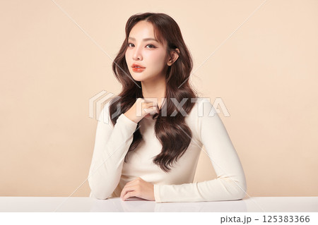 A beautiful young Asian woman with clean, fresh skin against a beige background. Skincare, facial treatment, cosmetology, beauty, and spa. An elegant portrait of an Asian woman. A beautiful young Asian woman with clean, fresh skin against a beige background. Skincare, facial treatment, cosmetology, beauty, and spa. An elegant portrait of an Asian woman. 125383366