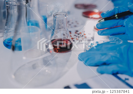 Researcher using a professional microscope Researcher using a professional microscope 125387841