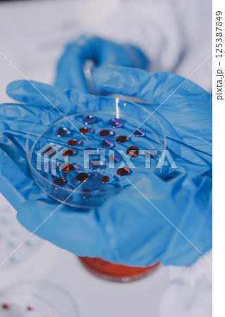 Researcher using a professional microscope Researcher using a professional microscope 125387849