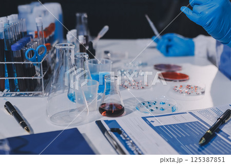 Researcher using a professional microscope Researcher using a professional microscope 125387851