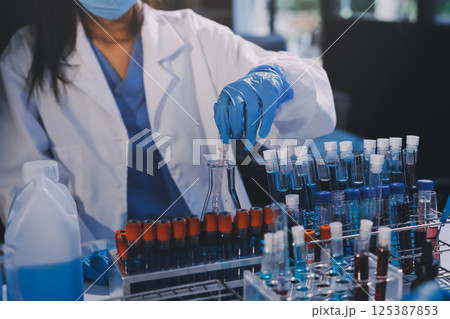 Researcher using a professional microscope Researcher using a professional microscope 125387853