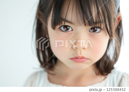 怒っている日本人の子供のアップ（決意・睨む・悔しさ・いじめ・許せない）	 125388432