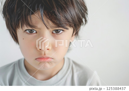 怒っている日本人の子供のアップ（決意・睨む・悔しさ・いじめ・許せない）	 125388437