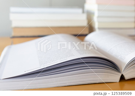 机の上に開いた英語の書籍 研究 学習のイメージ 125389509