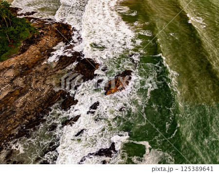 Top view seashore waves nature background,Amazing waves crashing on rocks seascape view Top view seashore waves nature background,Amazing waves crashing on rocks seascape view 125389641