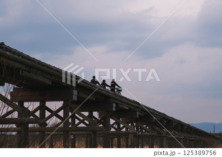 [流れ橋]歴史的な橋を渡る人々 125389756