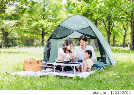 キャンプで料理を楽しむ仲良し家族・アウトドアイメージ 125390700