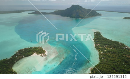 Aerial view Maupiti island in French Polynesia, turquoise water lagoon ocean channel, lush green vegetation, speedboat, mount Teurafaatui. Remote wild nature paradise, exotic summer travel background Aerial view Maupiti island in French Polynesia, turquoise water lagoon ocean channel, lush green vegetation, speedboat, mount Teurafaatui. Remote wild nature paradise, exotic summer travel background 125391513