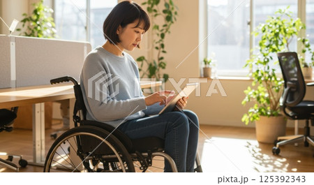 車椅子で働く日本人女性（ai生成画像） 125392343