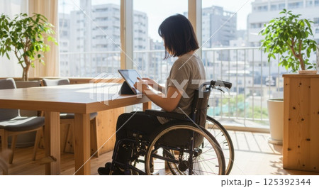 車椅子で働く日本人女性（ai生成画像） 125392344