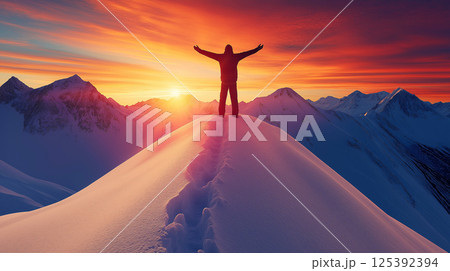 Hiker celebrating reaching snowy mountain peak at sunset 125392394