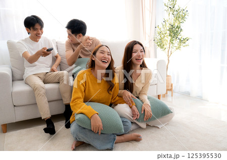 Group young asian friends watching TV together in a cozy living room at home with happy. 125395530