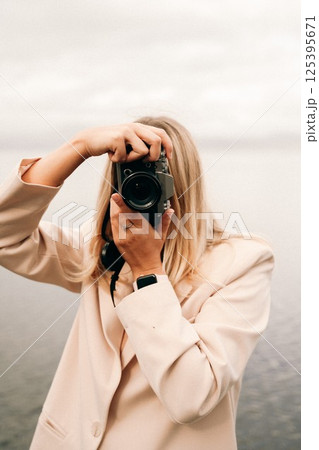 Woman Taking Photograph with Vintage Camera Outdoors Woman Taking Photograph with Vintage Camera Outdoors 125395671