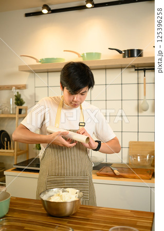 Asian male baker wrapping whipped cream for storage Asian male baker wrapping whipped cream for storage 125396258