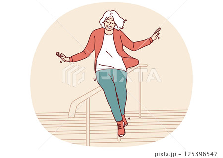 Elderly woman slides down stair railing having fun and being active after retirement 125396547