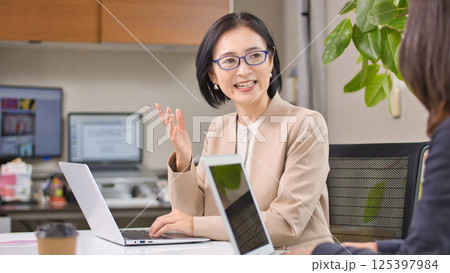 オフィスで打ち合わせをするミドル女性 125397984