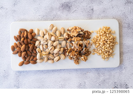 Mix of different nuts on a white plate. View from above. Mix of different nuts on a white plate. View from above. 125398065