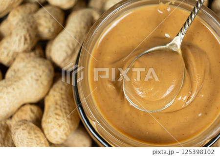 Creamy Peanut Butter in Spoon and Raw Peanuts Creamy Peanut Butter in Spoon and Raw Peanuts 125398102