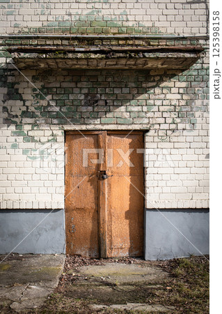 Rustic Door with Cracked Paint and Weathered Wall. Rustic Door with Cracked Paint and Weathered Wall. 125398158