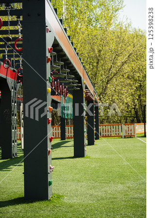 Sports ground outdoors for kids and adult. Successful training concept. Open air gym, street workout concept. Hanging monkey bars on kids playground. Sports ground outdoors for kids and adult. Successful training concept. Open air gym, street workout concept. Hanging monkey bars on kids playground. 125398238