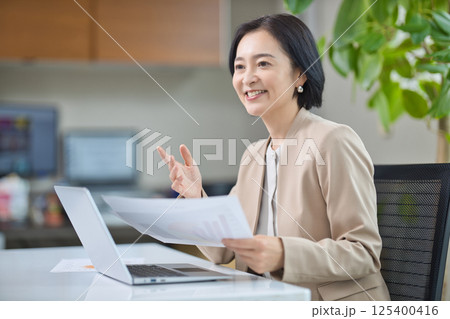 オフィスで打ち合わせをするミドル女性 125400416
