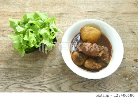 beef curry or Mussamun Indian food with slice potato on bowl eat with fresh green oak beef curry or Mussamun Indian food with slice potato on bowl eat with fresh green oak 125400590