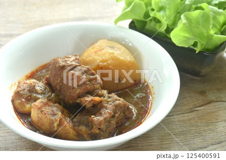 beef curry or Mussamun Indian food with slice potato on bowl eat with fresh green oak 125400591