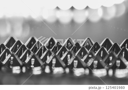 Close-up macro of sewing studs arranged in symmetrical rows in black and white abstraction Close-up macro of sewing studs arranged in symmetrical rows in black and white abstraction 125401980