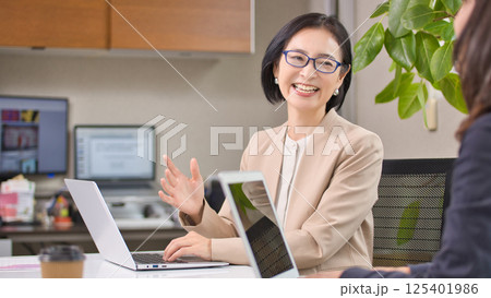 オフィスで打ち合わせをするミドル女性 125401986