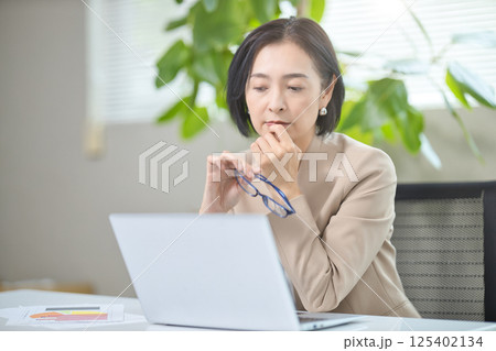 オフィスで打ち合わせをするミドル女性 オフィスで打ち合わせをするミドル女性 125402134