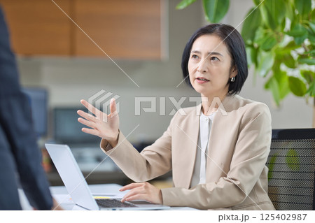オフィスで打ち合わせをするミドル女性 125402987
