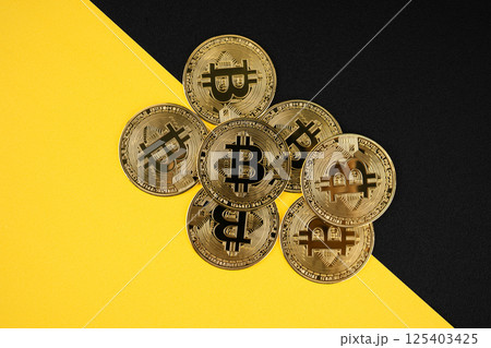 Close up of a shiny Bitcoin BTC Cryptocurrency Coin on yellow and black leather. Close up of a shiny Bitcoin BTC Cryptocurrency Coin on yellow and black leather. 125403425