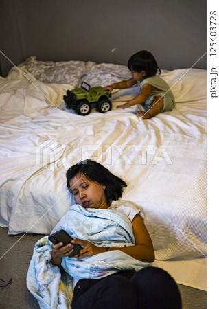 Mother Was Lying On The Floor Because She Was Tired From Taking Care Of The Child, Background for advertising and wallpaper in relaxion and lifestyle scene. 125403728