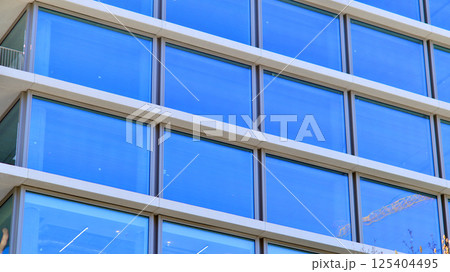 Downtown corporate business district architecture. Glass reflective office buildings against blue sky and sun light. Economy, finances, business activity concept. Rising sun on the horizon. 125404495