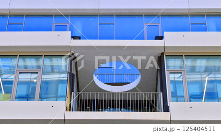 Downtown corporate business district architecture. Glass reflective office buildings against blue sky and sun light. Economy, finances, business activity concept. Rising sun on the horizon. 125404511