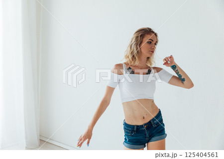 Blonde woman listening to music and dancing Blonde woman listening to music and dancing 125404561