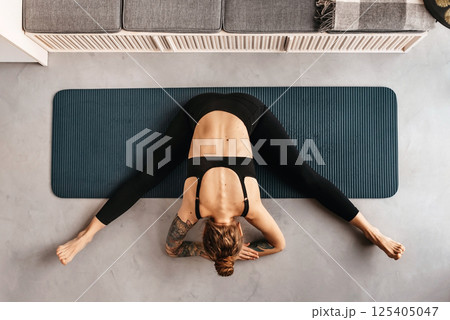 Woman Doing Yoga Exercise on Mat Top View 125405047