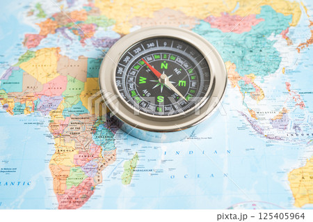 Bangkok, Thailand January 20, 2022 Compass on world map background to travel, geography, tourism and exploration concept. 125405964