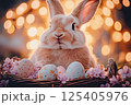 Easter bunny with basket of colorful eggs in a blooming garden. 125405976
