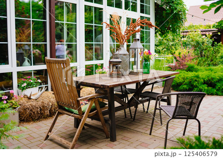 wooden table with lanterns and dried flowers. The yard in the house. 125406579