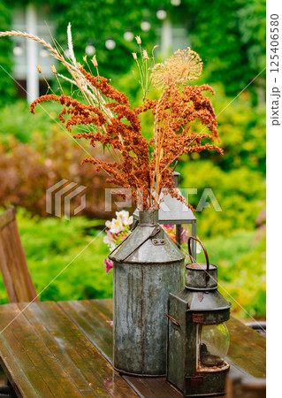 Bouquet of dried flowers in a vintage balloon on a wooden table in the garden. 125406580