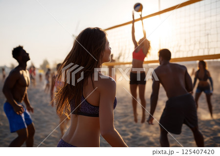 Young and athletic people playing volleyball on the beach Young and athletic people playing volleyball on the beach 125407420
