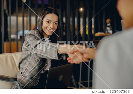 A Professional Handshake in a Modern Office Environment Signifying Mutual Respect and Intent A Professional Handshake in a Modern Office Environment Signifying Mutual Respect and Intent 125407568