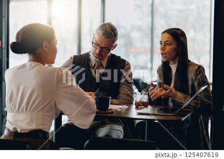 Business meeting in a cozy cafe atmosphere enhances productivity and collaboration Business meeting in a cozy cafe atmosphere enhances productivity and collaboration 125407619