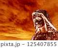Crying statue of the virgin Mary against a burning sky 125407855