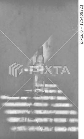 Moody Monochrome Empty Bottle with Dramatic Shadows Moody Monochrome Empty Bottle with Dramatic Shadows 125408223